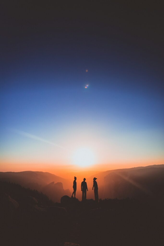 Silhouette of a person overlooking a valley glowing in golden sunrise light
